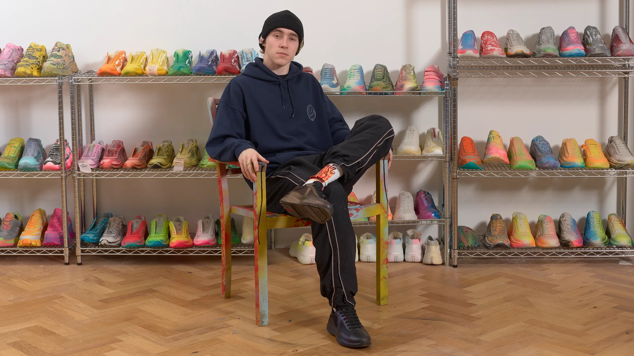 Prada's NFT is designed by Cassius Hirst, sitting in this image amongst his custom shoes.